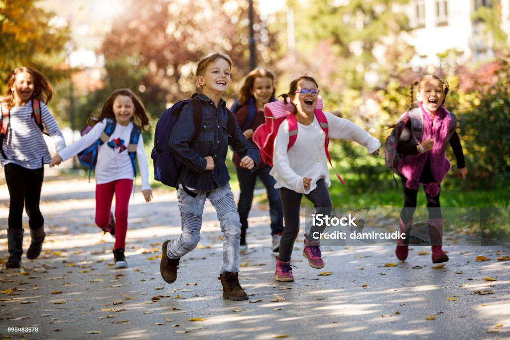 School kids running in schoolyard Child Stock Photo