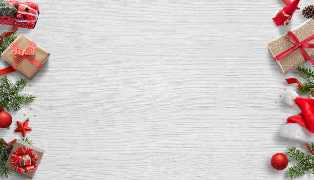 istock Christmas composition with Christmas decorations on side. Free space in the middle for greeting text. Top view. White wooden table in background. 895493516
