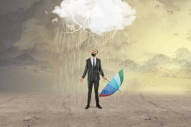istock Businessman with umbrella under rain storm 895497558