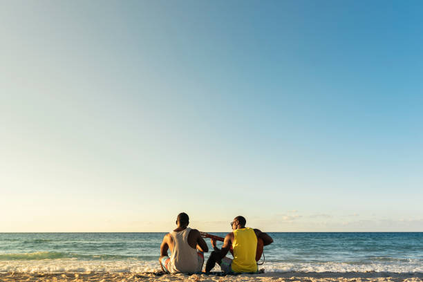 istock Two cuban friends having fun in the beach with his guitar. 895497756