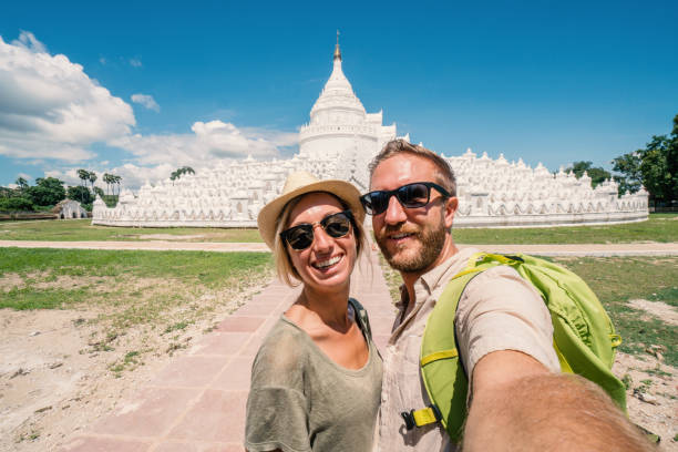 istock Travel couple taking selfie with white temple, Myanmar 895510516