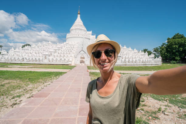 istock Young woman taking selfie in white temple, Myanmar 895510600