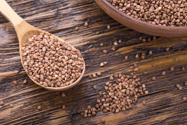 istock standing on a wooden background earthenware dish with raw buckwheat. top view 895524810