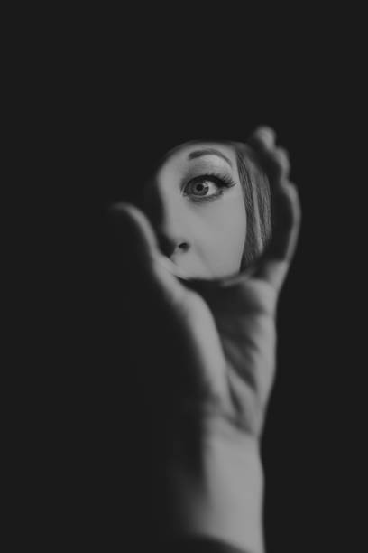 Woman looking at her eye in a small mirror artistic conversion