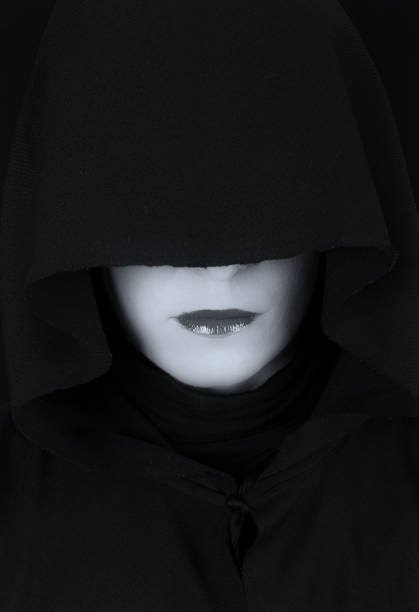 istock Woman in black cape with sad face and red lips portrait artistic conversion 895534966