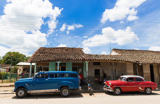 Santa Clara: Street life view with cuban peoples before a store and a blue and red Chevrolet vintage car on the street in Santa Clara Cuba - Serie Cuba Reportage