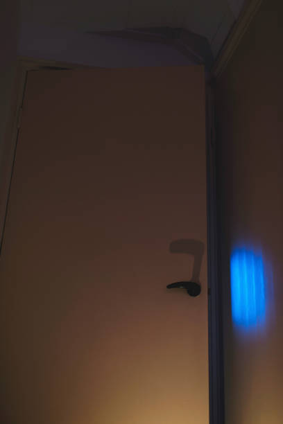 istock Ajar door in home with spooky blue light coming out. 895576704