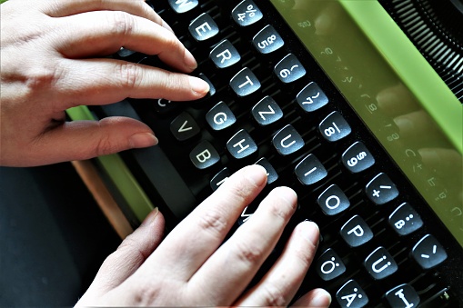 An Image of a vintage typewriter with hands