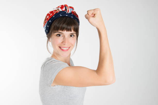 A strong woman showing her bicep A strong woman showing her muscle and fist rolled up sleeves stock pictures, royalty-free photos & images