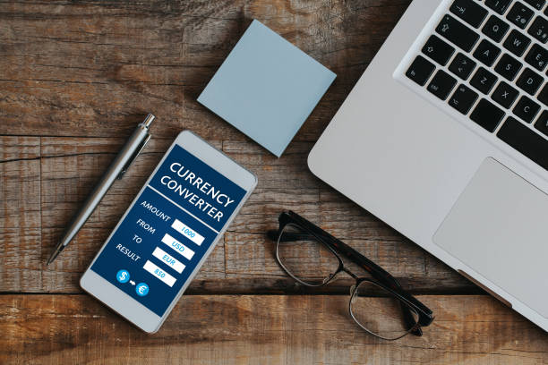 istock Currency converter mobile app in a mobile phone screen at the office. 895577274