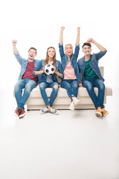 istock friends with soccer ball sitting on sofa 895595274