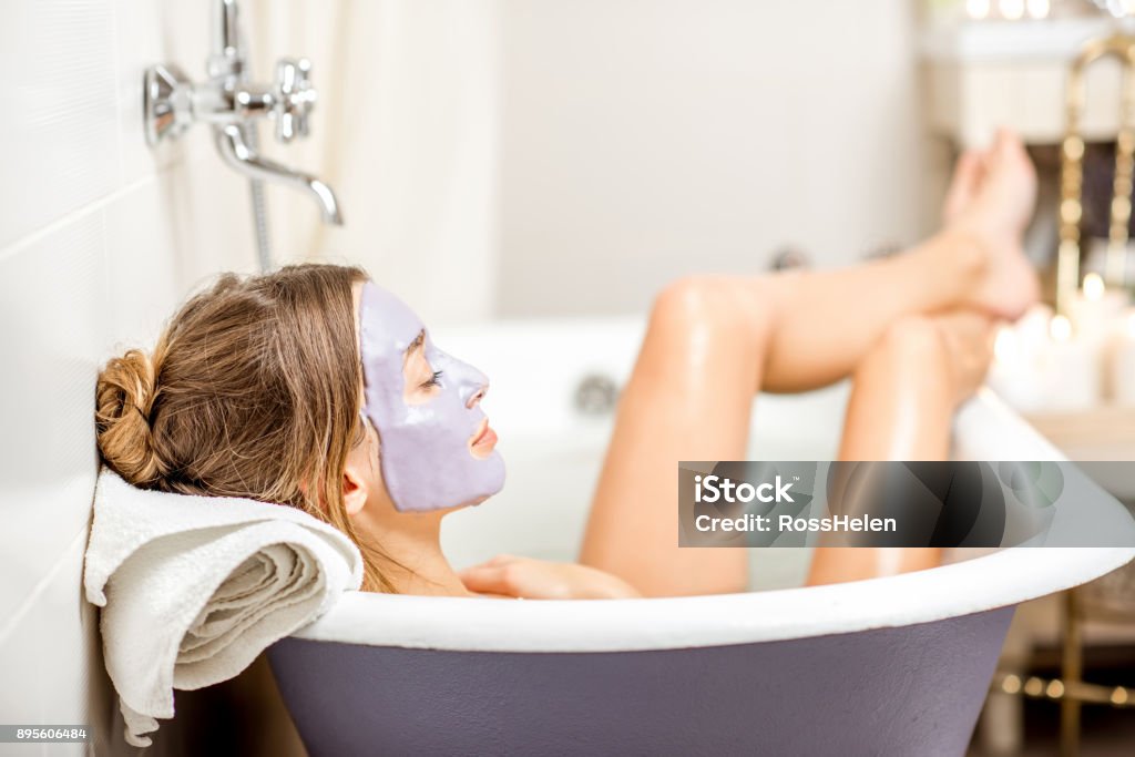 Donna con maschera facciale in bagno - Foto stock royalty-free di Vasca da bagno