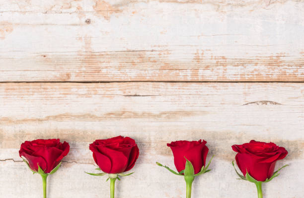 istock Red rose flowers on rustic wooden background 895609576