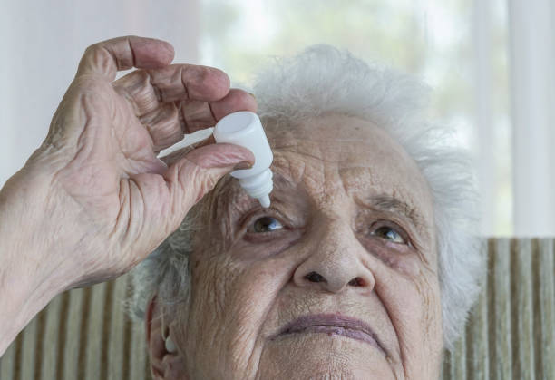 istock senior woman applying  eye drop on her eye 895617088