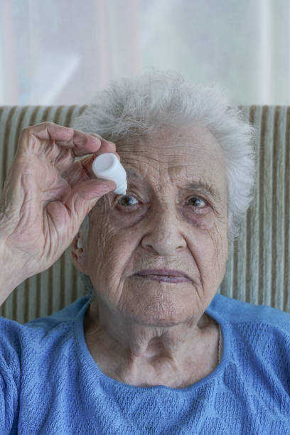 istock senior woman applying  eye drop on her eye 895617092