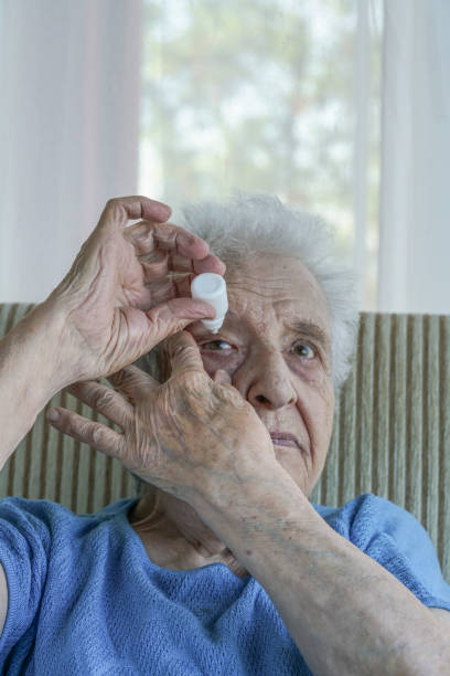 istock senior woman applying  eye drop on her eye 895617096