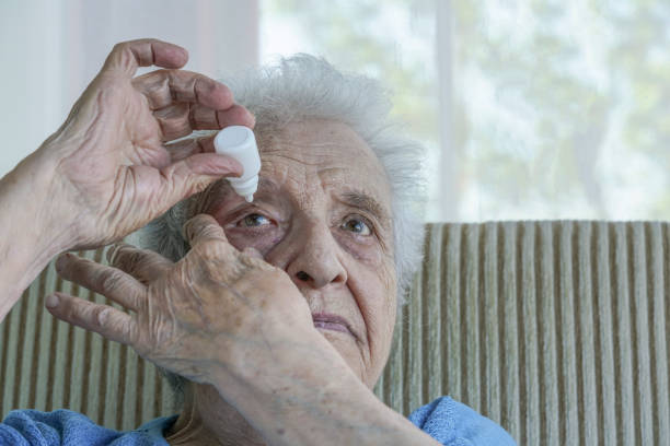 istock senior woman applying  eye drop on her eye 895617124