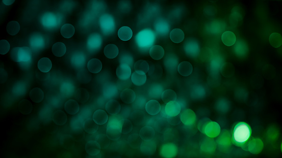 Green Festive Beautiful abstract Background with bokeh lights. Wide screen Holiday Texture, defocused. Can be used as Wallpaper, filling for a website