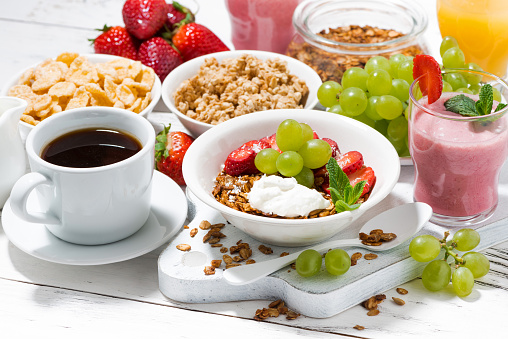 healthy breakfast with fruits, granola and milkshake on white background, horizontal