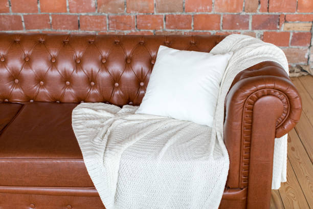 istock Brown sofa on which lie a white blanket and pillow 895657902