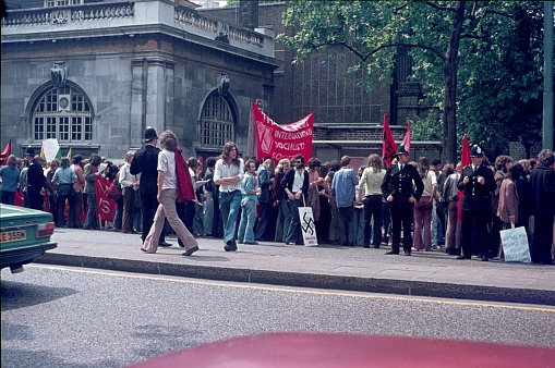 London, England, UK, 1973. Students gather with their banners and signs for a demonstration in London. The police accompany the demonstrators. If you look at the banners, you can see the political motivation of the young students at the beginning of the 70s of the previous century.