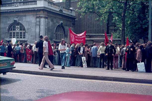 Demonstration of young students in London, 1973 London, England, UK, 1973. Students gather with their banners and signs for a demonstration in London. The police accompany the demonstrators. If you look at the banners, you can see the political motivation of the young students at the beginning of the 70s of the previous century. marching photos stock pictures, royalty-free photos & images