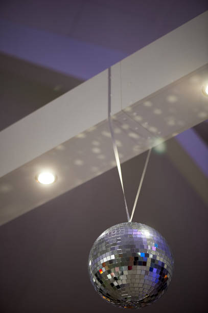 istock The high white ceiling with exposed beams. Decorated with disco balls.With the backlight. Night life 895671396