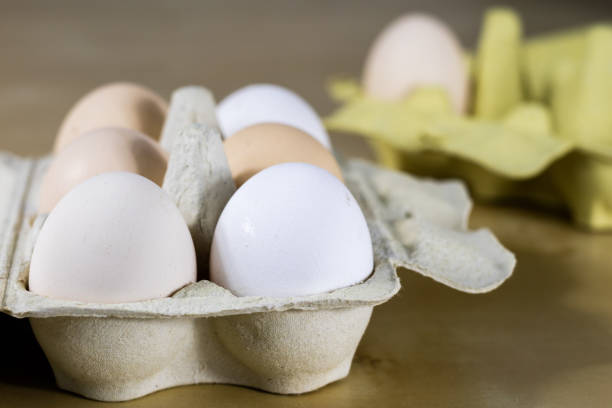 istock Eggs in molds on a wooden kitchen table. Hen egg in the kitchen atmosphere. black background 895678780