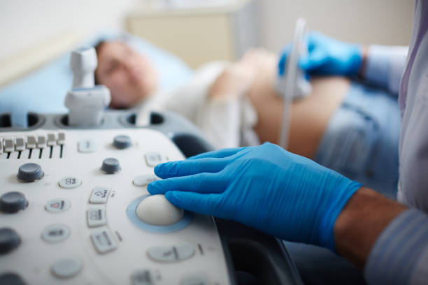 Making ultrasound check-up Hand of doctor in glove pressing button on panel of ultrasound equipment during regular check-up of pregnant woman diagnostic medical tool stock pictures, royalty-free photos & images