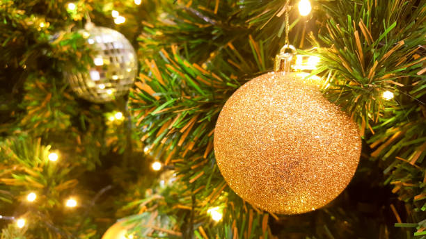 boule de noël glister or suspendu à l’arbre de pin. - glister photos et images de collection