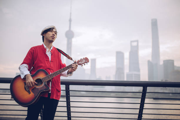istock Man playing guitar near the river 895729364