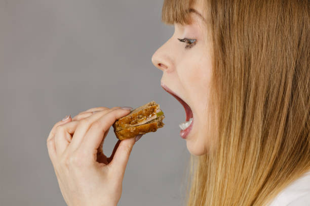 istock Woman eating sandwich, taking bite 895746524