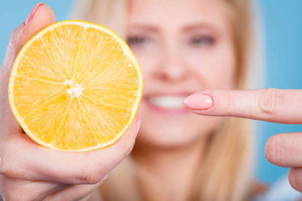 istock Woman holding fruit lemon or orange 895747010