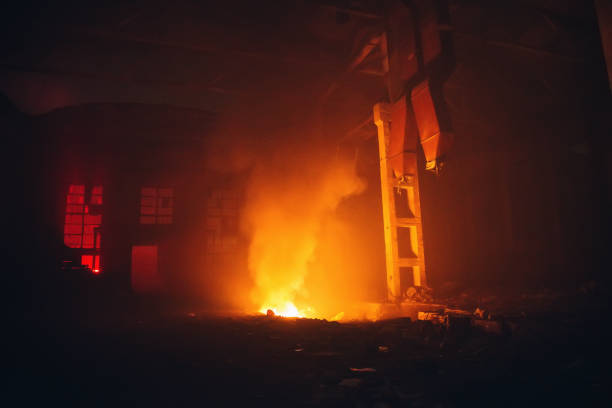 istock Burning large industrial warehouse hall. Fire inside factory interior 895752478