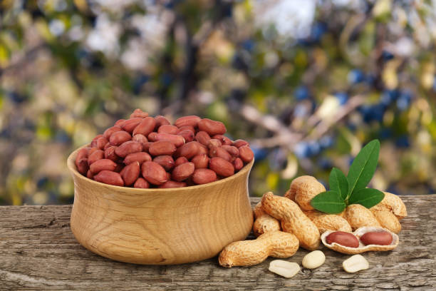 istock peanuts with leaf in bowl on old wooden table with a blurry garden background 895756616