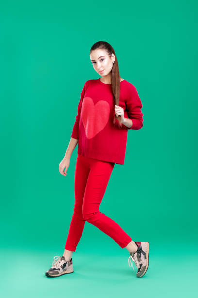 istock woman in red sweater on green background 895756710