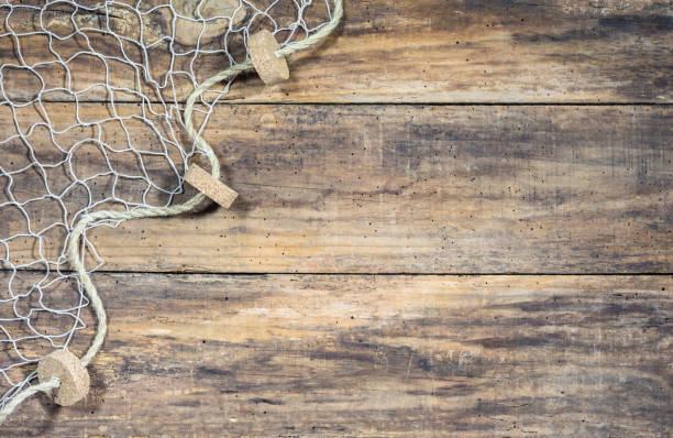 Fishing net over rustic wooden background Fishing net background texture over rustic brown wood with copy space commercial fishing net photos stock pictures, royalty-free photos & images