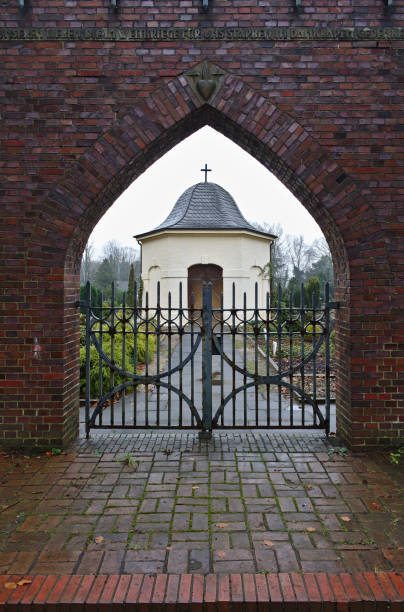 osterholz scharmbeck、ドイツの小さな葬儀チャペルへ教会の墓地の門を通��してください。 - osterholz ストックフォトと画像