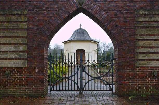 osterholz scharmbeck、ドイツの小さな葬儀チャペルへ教会の墓地の門を通してください。 - osterholz ストックフォトと画像