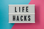 life hacks - text on a display on blue and pink bright background.