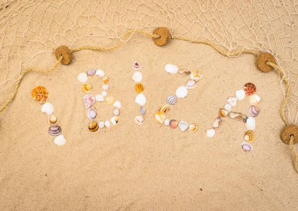 Word Ibiza writing with seashells on sandy beach