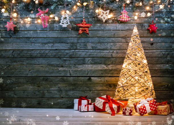 istock Holidays background with illuminated Christmas tree, gifts and decoration. 895798788