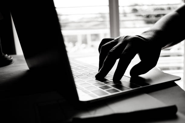 istock hands of anonymous hackers typing code on keyboard of laptop for remotely reach and receiving personal information online networking, Internet Crime Payment Security Concept, Silhouette black white 895802076