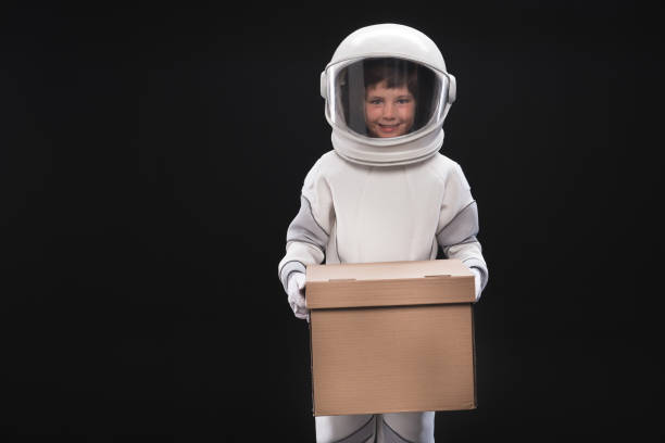 istock Optimistic cute child astronaut is keeping carton 895805696