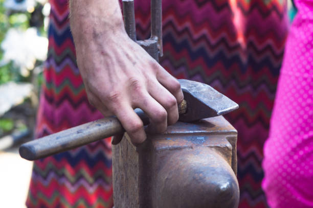istock blacksmith performs the forging of hot glowing metal on the anvil 895808084