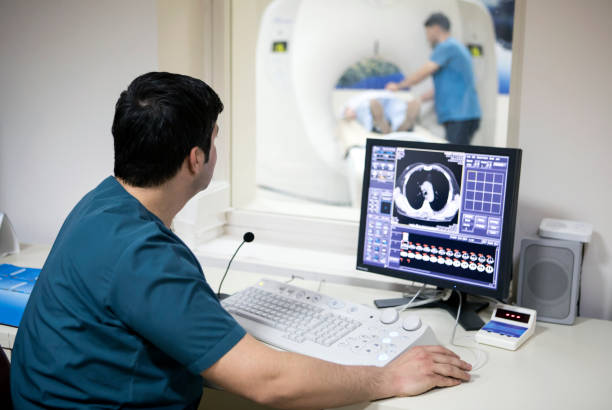 Radiologist at work Radiologist reading a CAT scan cat scan stock pictures, royalty-free photos & images