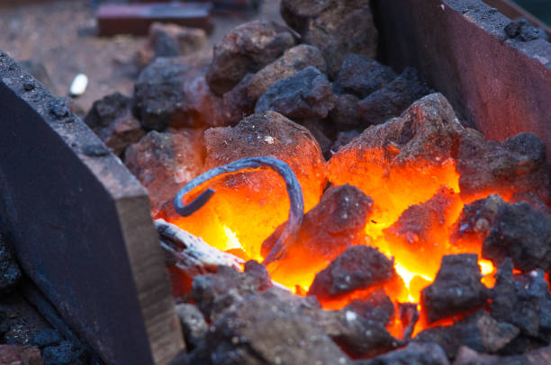 istock blacksmith furnace with burning coals, tools, and glowing hot metal workpieces 895823934