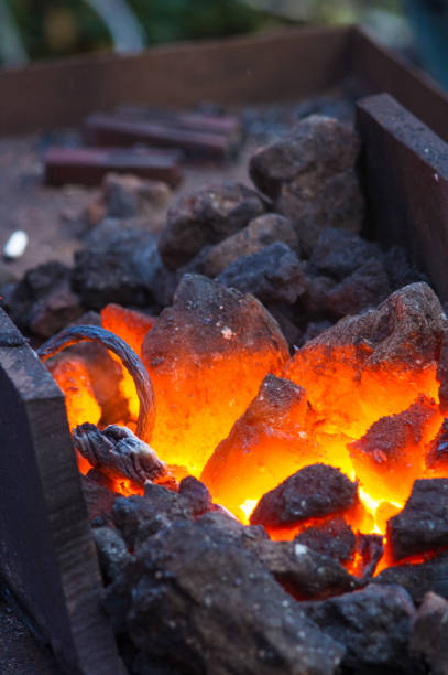 istock blacksmith furnace with burning coals, tools, and glowing hot metal workpieces 895826348