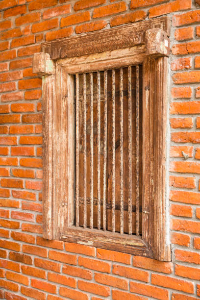 istock Ancient wooden window and iron bars on brick wall 895853384