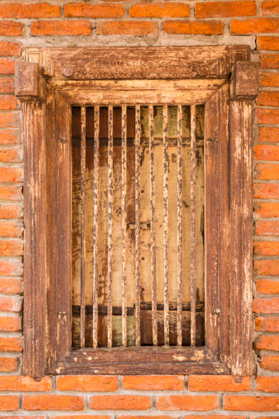 istock Ancient wooden window and iron bars on brick wall as background 895853414